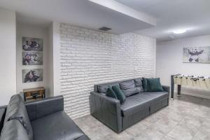 ein Wohnzimmer mit Sofa und Ziegelwand in der Unterkunft TWO Modern Apartment Minutes to NYC in Jersey City