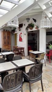 uma sala de jantar com mesas e cadeiras e pássaros na parede em Pousada Bonns Ventos em Ilhabela