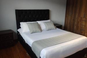 1 dormitorio con 1 cama blanca grande y 2 almohadas en Finca La Sara, en Ubaté