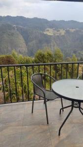 a table and a chair on a balcony with a view at Finca La Sara in Ubaté