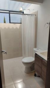 a bathroom with a toilet and a shower and a sink at Finca La Sara in Ubaté