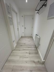 un pasillo con paredes blancas y suelo de madera en churchward house flat 4 en Chertsey