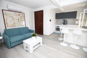 a living room with a blue couch and a kitchen at Francesco's Home in Monteverde in Rome