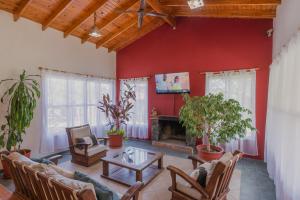 sala de estar con paredes rojas y chimenea en Cerro de los Duendes en Santa Rosa de Calamuchita