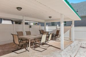 a patio with a wooden table and chairs at Happy Ours in Foley