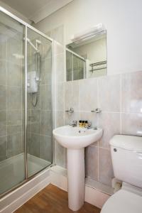 a bathroom with a shower and a sink and a toilet at The Kings Arms Otterton in Budleigh Salterton
