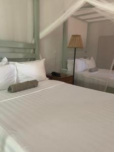 une chambre d'hôtel avec deux lits et une lampe dans l'établissement Kara O Mula Mulanje, à Mulanje