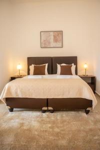 1 dormitorio con 1 cama grande y 2 lámparas en las mesas en Decifer Sport Resort en Belas