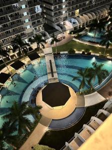 an overhead view of a large swimming pool with palm trees at Shell Residences by Amonbrey Suite nr airport in Manila