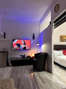 a living room with a tv on a purple wall at Rich homes in Baatsona