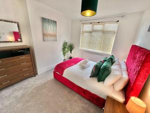 1 dormitorio con 1 cama y 1 sofá rojo en Large Four Bedroom - With Hot Tub and Parking - Sleeps 8 en Poole