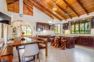 cocina con techos de madera, mesa y sillas en Villa Roble Alto, en Guanacaste