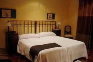 1 dormitorio con 1 cama grande con sábanas blancas en Cincosombreros, en Gallegos de San Vicente