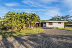 una casa con palmeras y un camino de entrada en Villa Roble Alto, en Guanacaste