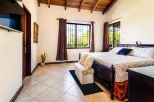 Villa Roble Alto في غواناكاستي: غرفة نوم بسرير ونافذة كبيرة