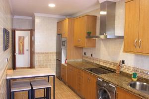 a kitchen with wooden cabinets and a sink at Gran Apartamento Andévalo in El Cerro de Andévalo