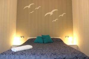 - une chambre avec un lit avec des oiseaux sur le mur dans l'établissement Gran Apartamento Andévalo, à El Cerro de Andévalo