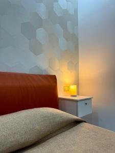 ein Schlafzimmer mit einem Bett und einem Tisch mit einer Lampe in der Unterkunft Beatrice Home in Pompei