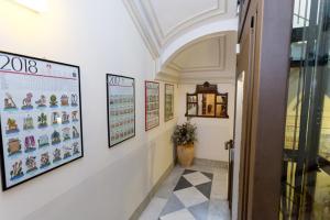 um corredor de um edifício com imagens na parede em Crociferi B&B em Catânia