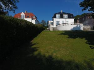 een groot wit huis met een zwart dak en een tuin bij aday - Aalborg City Center big apartment in Aalborg