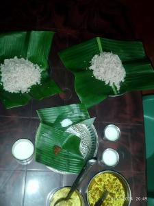 a table with two green leaves with rice and a spoon at Kyathanamakki Base Camp Stay in Kalasa