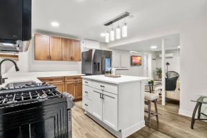 a kitchen with white cabinets and a black stove at BRAND NEW Private and Modern 2BR Unit in Minneapolis +10 photos