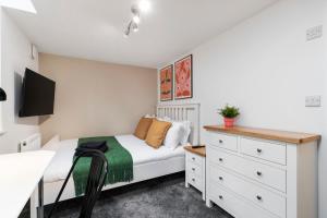 a small bedroom with a bed and a dresser at Cosy One Bed Apt in Leeds City in Leeds