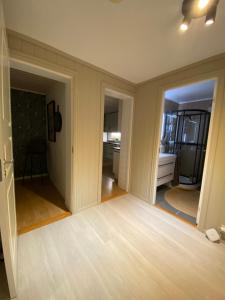 una sala de estar vacía con suelo y paredes de madera en Leilighet i enebolig, en Bergen
