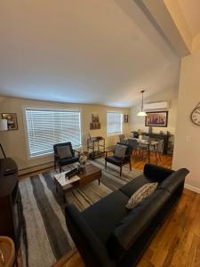 a living room with a couch and a table at Chic modern bedroom 5 mins from JFK in Locust Manor