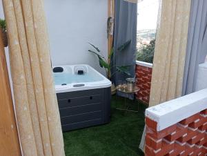 La salle de bains est pourvue d'un lavabo et d'une fenêtre avec de l'herbe verte. dans l'établissement Casinhas do Miga, à Santa Comba Dão