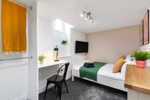 a small bedroom with a bed and a desk at Cosy One Bed Apt in Leeds City in Leeds