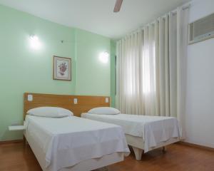 Duas camas num quarto com paredes brancas em Hotel San Gabriel em São Paulo