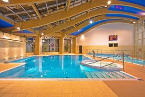 a large swimming pool in a building at Alga Baltic Resort in Świnoujście