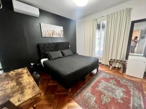 a bedroom with a bed with a black ottoman at Hotel Boutique Tremo Bellavista Suite in Santiago