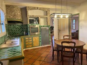 eine Küche mit einem Tisch und einem Esszimmer in der Unterkunft La Meynardière in Saint-Pierre-de-Vassols