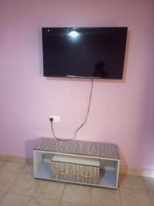 a flat screen tv hanging on a pink wall at Verona Apartments in Thika