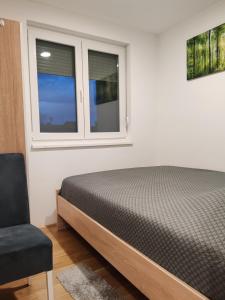 a bedroom with a bed and a window at Apartman Max in Modriča