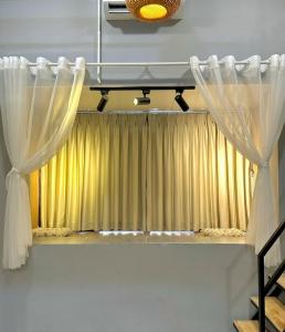 a window with curtains on a shelf in a room at Stay&Chill S.6 - Tranquil home in Saigon's heart in Ho Chi Minh City