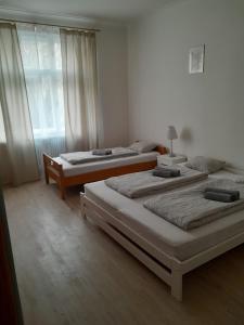 - une chambre avec 3 lits et une fenêtre dans l'établissement LUBERT APARTMÁNY s.r.o, à Prague