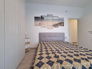 een slaapkamer met een bed en een foto van een strand bij Onda Azzurra in Imperia