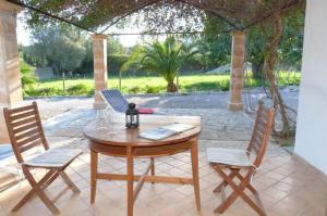 a wooden table and chairs on a patio at Casa Villa Las Encinas in Pollença