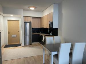 a kitchen with a table and chairs and a refrigerator at Kempele city center 2 in Kempele
