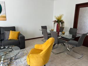 a living room with a table and chairs at Populo Beach Villa, Walk to Beach, Air Conditioning and Heating, near Ponta Delgada in Livramento