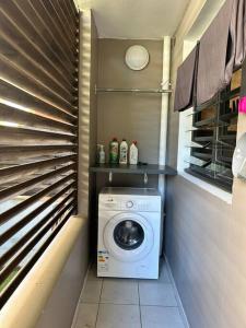 uma máquina de lavar e secar roupa num pequeno quarto em Studio le Zéphyr Ste Clotilde em Saint-Denis