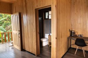 a bathroom with a toilet and a table and a desk at Cabañas Casa de Niebla in Pluma Hidalgo
