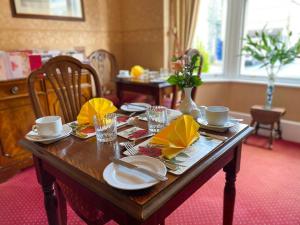 a wooden table with plates and napkins on it at Number 10 Bed & Breakfast in Keswick +18 photos