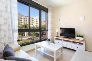 a living room with a tv and a large window at Alquilaencanarias El Palm Mar in Palm-mar