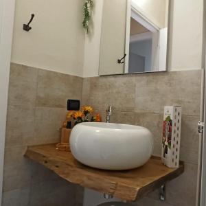 y baño con lavabo blanco y espejo. en La casetta di Elly, en Puegnago sul Garda