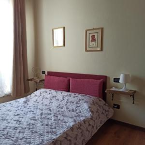 1 dormitorio con 1 cama grande con almohadas rojas en La casetta di Elly, en Puegnago sul Garda