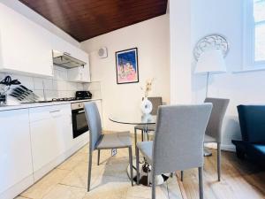 kuchnia i jadalnia ze stołem i krzesłami w obiekcie Crouch End Garden Apartment! w Londynie